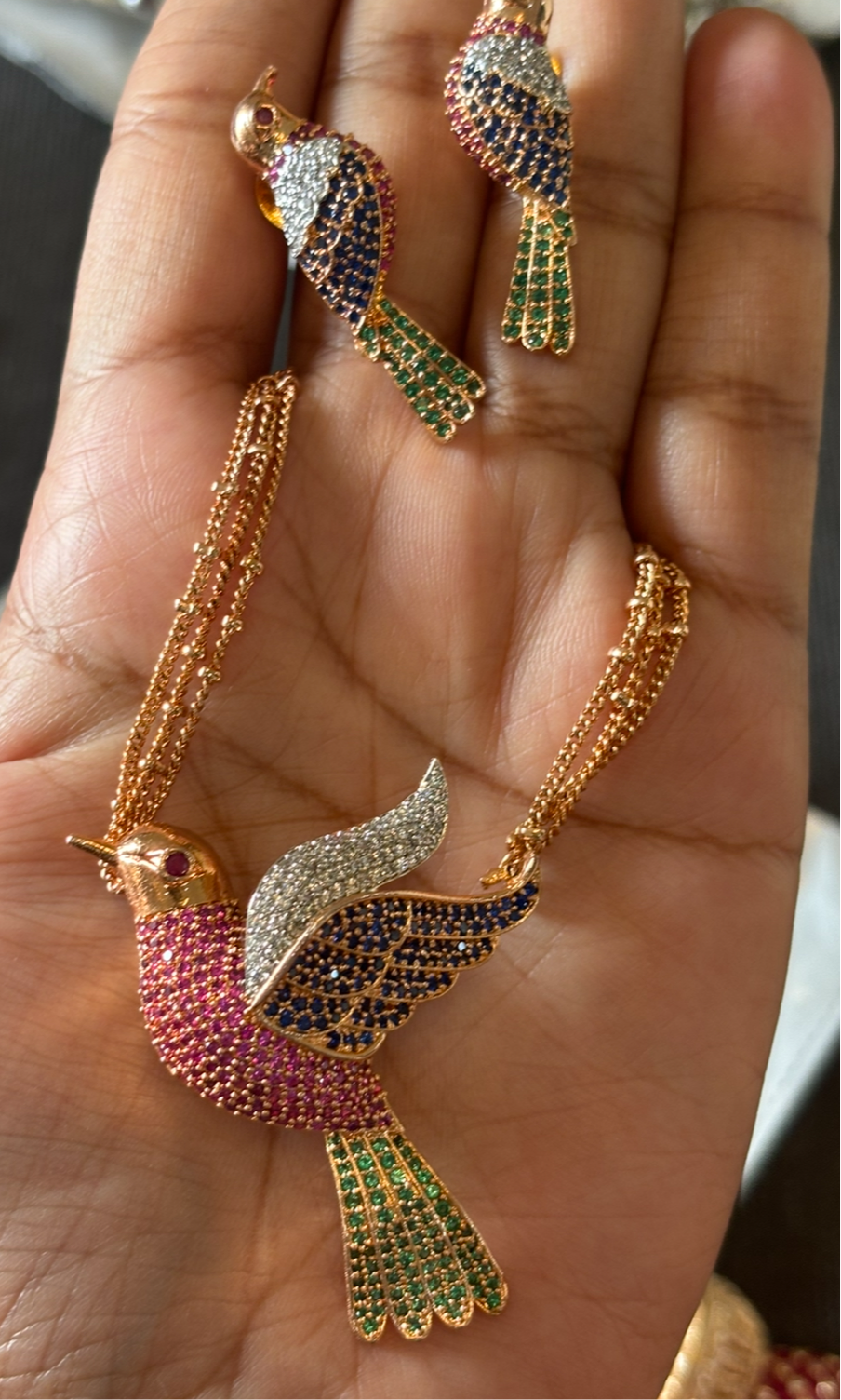 Pendant set with multicolour bird motif and gemstone detailing shown in full view